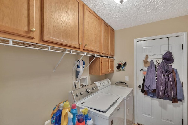 laundry area featuring cabinet space, washing machine and dryer, and a textured ceiling