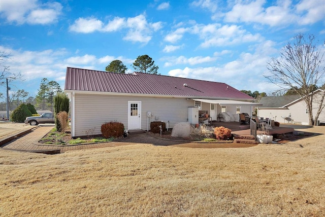 back of property featuring a patio area, metal roof, and a yard