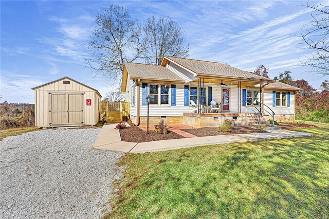 view of front of house featuring covered porch, a storage unit, and a front yard