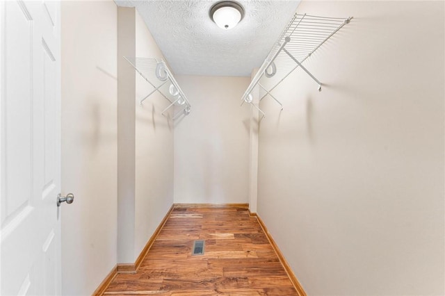 spacious closet featuring hardwood / wood-style floors