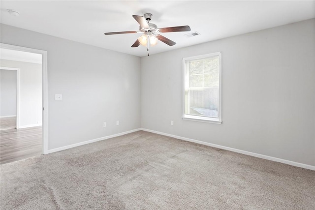 carpeted spare room featuring ceiling fan