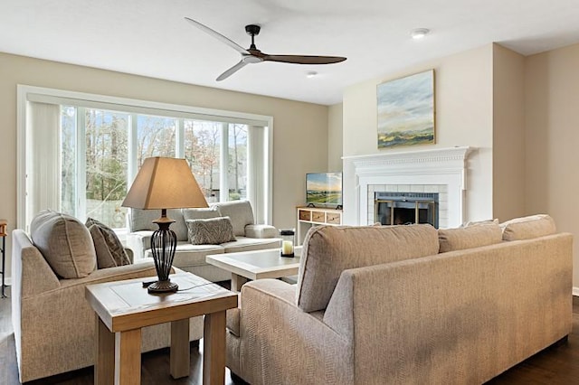 living room featuring dark hardwood / wood-style floors, ceiling fan, and a fireplace