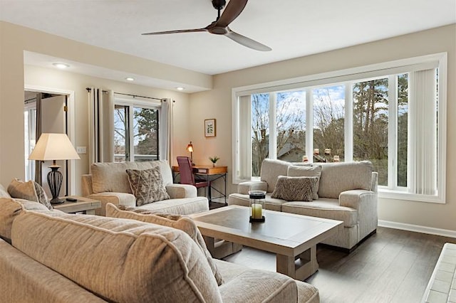 living room with a healthy amount of sunlight, dark hardwood / wood-style floors, and ceiling fan