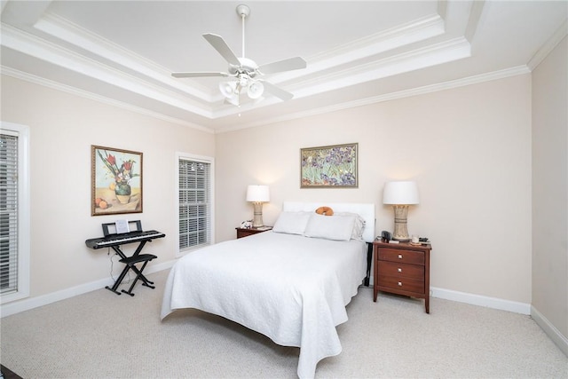 carpeted bedroom featuring ceiling fan, a tray ceiling, and crown molding