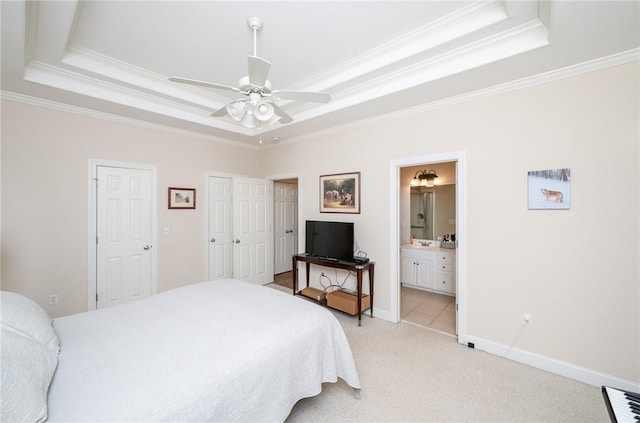 bedroom featuring ensuite bath, a raised ceiling, ceiling fan, and crown molding