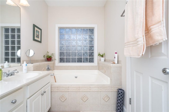 bathroom featuring vanity and tiled bath