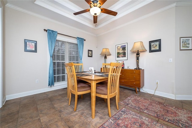 dining space featuring ornamental molding, ceiling fan, and a tray ceiling