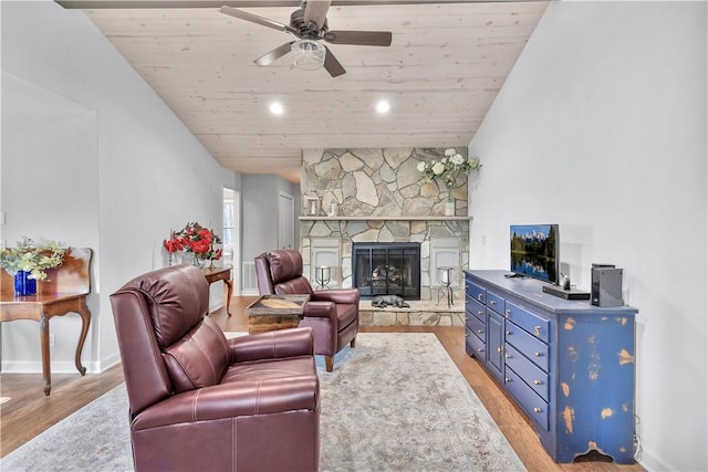 living room featuring a fireplace, vaulted ceiling, ceiling fan, light wood-type flooring, and wood ceiling