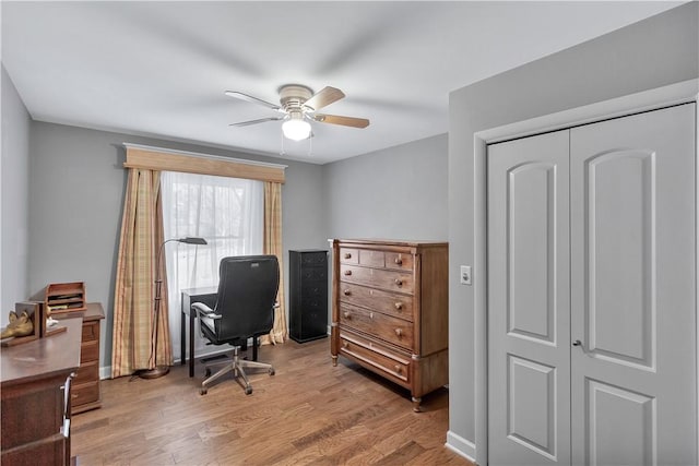 office with light wood-type flooring and ceiling fan