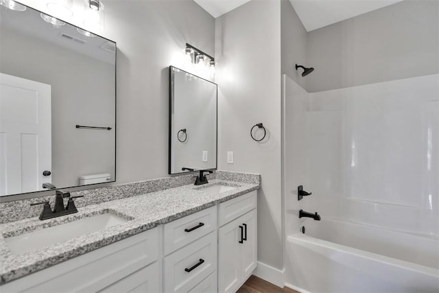 full bathroom with toilet, hardwood / wood-style flooring, bathing tub / shower combination, and vanity