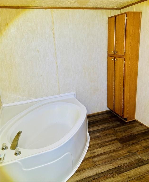 bathroom with hardwood / wood-style floors and a bath