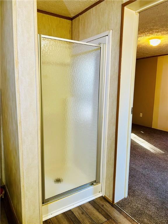 bathroom featuring a shower with door and hardwood / wood-style floors