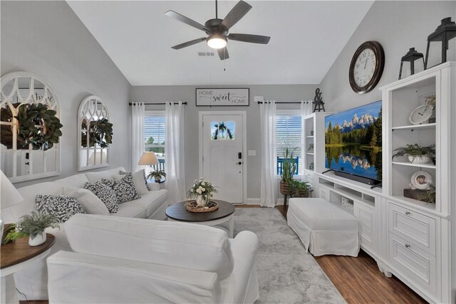 living room with lofted ceiling, ceiling fan, and wood-type flooring