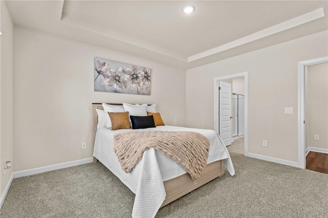 carpeted bedroom featuring a walk in closet, a tray ceiling, and a closet