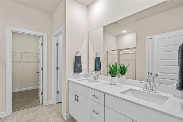 bathroom with an enclosed shower, vanity, and tile patterned flooring