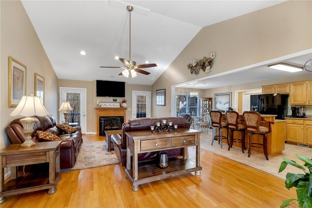 living room featuring high vaulted ceiling, ceiling fan, and light hardwood / wood-style flooring