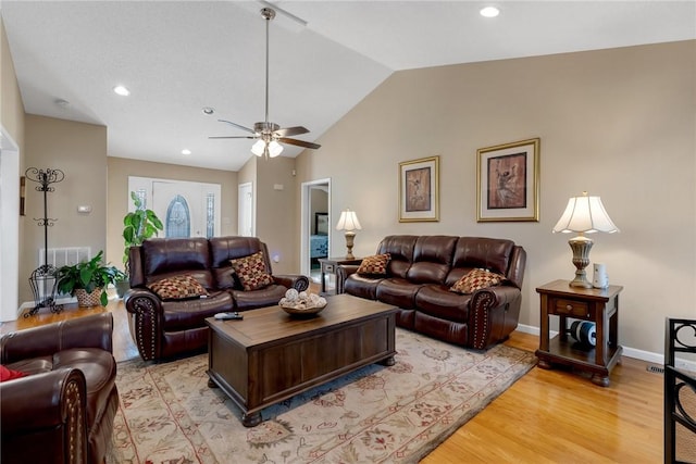 living room featuring ceiling fan, light wood-type flooring, and vaulted ceiling