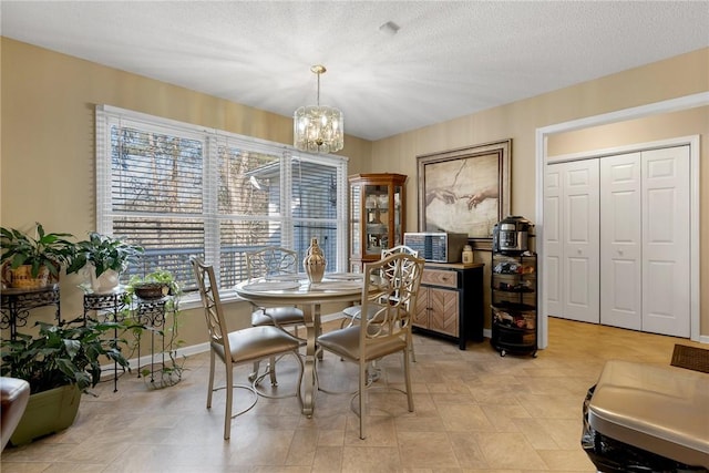 dining space with a textured ceiling and a chandelier