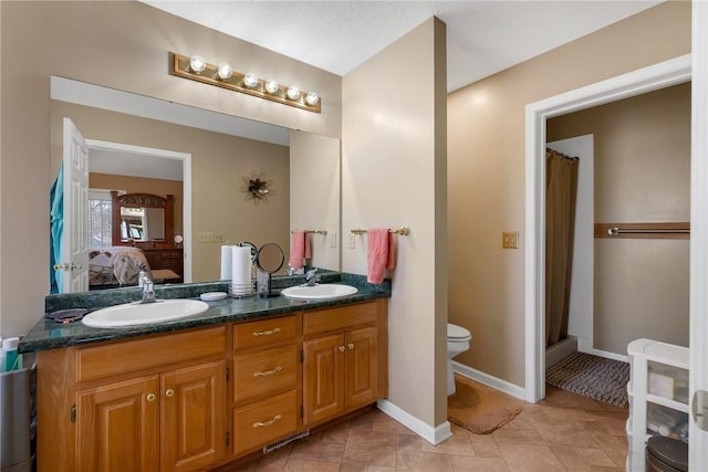 bathroom with toilet, vanity, tile patterned flooring, and curtained shower