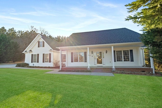 view of front of property featuring covered porch, a front lawn, and roof with shingles