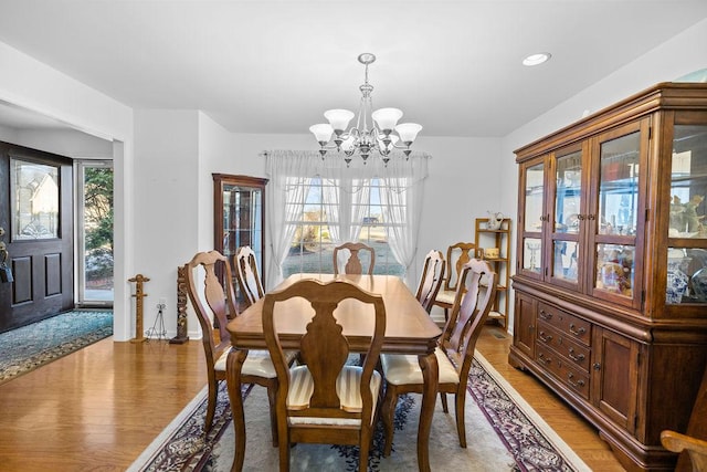 dining room with recessed lighting, wood finished floors, and an inviting chandelier