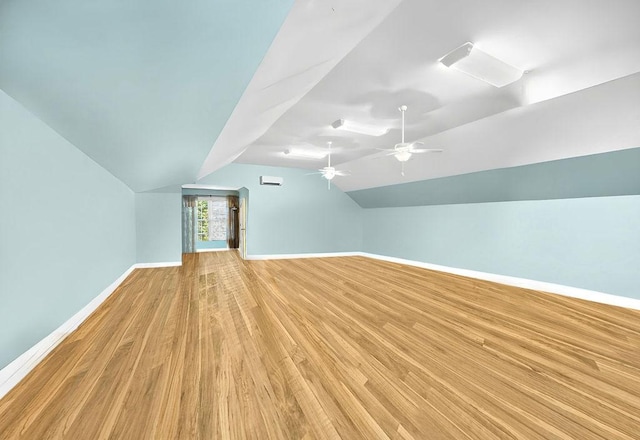 additional living space with lofted ceiling, ceiling fan, light wood finished floors, and baseboards