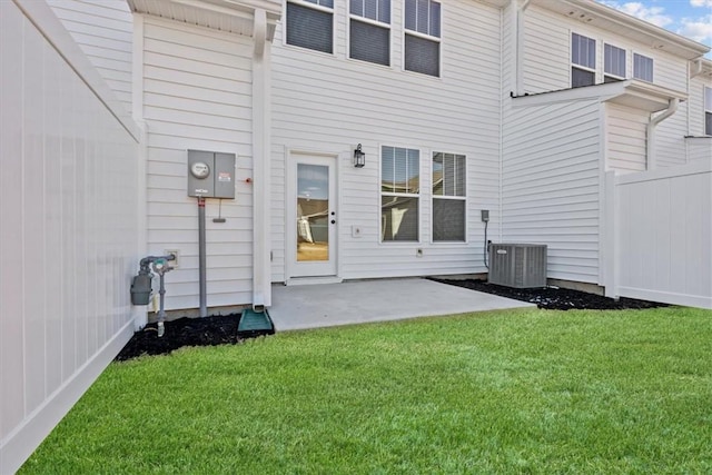 rear view of property featuring central AC, a patio area, and a lawn