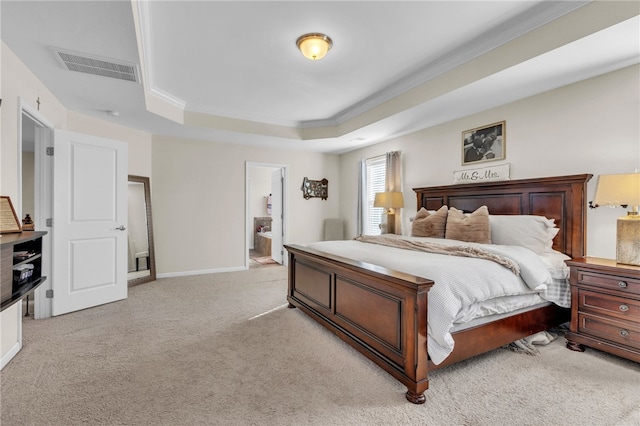 bedroom featuring ensuite bathroom, light colored carpet, a tray ceiling, and ornamental molding