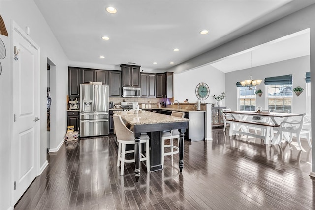 kitchen featuring stainless steel appliances, dark hardwood / wood-style floors, a chandelier, and pendant lighting