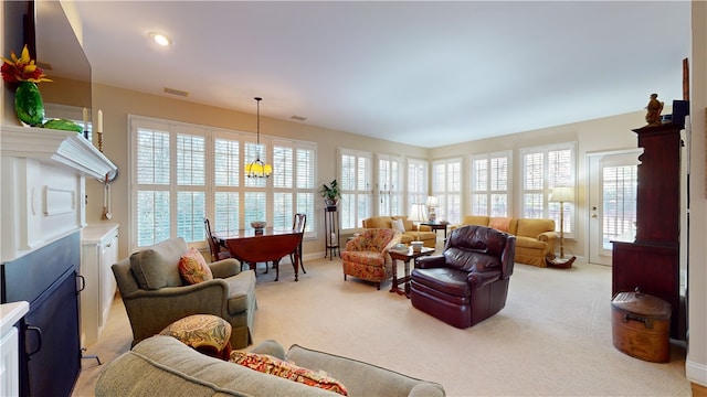 living room with light carpet and a chandelier