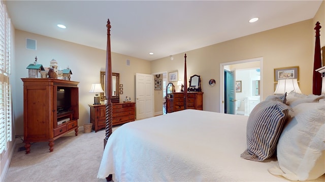 bedroom featuring light colored carpet and ensuite bath