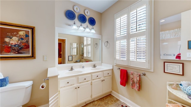 bathroom featuring toilet, vanity, and tile patterned flooring