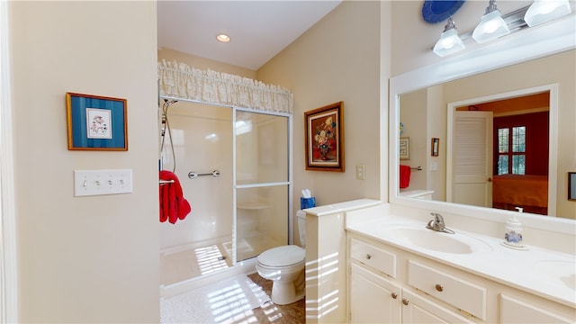 bathroom with a shower with shower door, toilet, and vanity