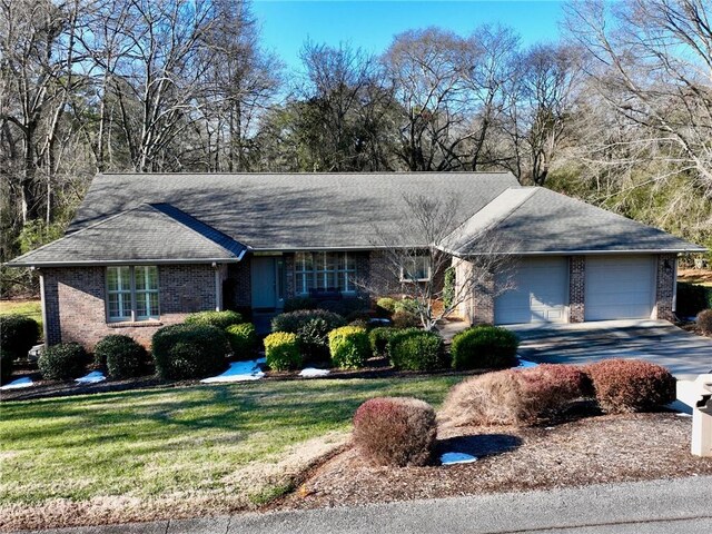 single story home featuring a front lawn and a garage