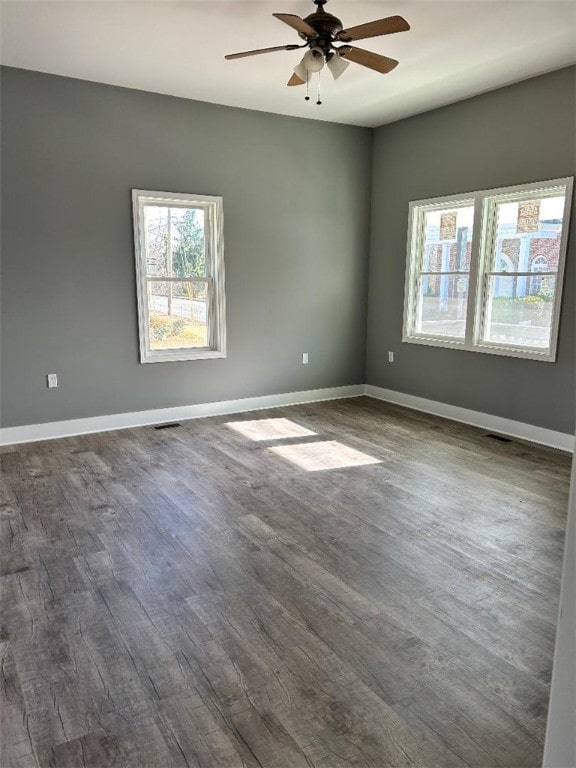 unfurnished room with ceiling fan and dark wood-type flooring