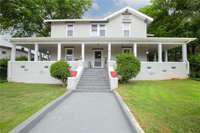 farmhouse-style home with a front yard and covered porch