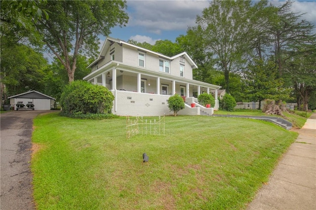 farmhouse inspired home with a porch, a front lawn, a garage, and an outbuilding