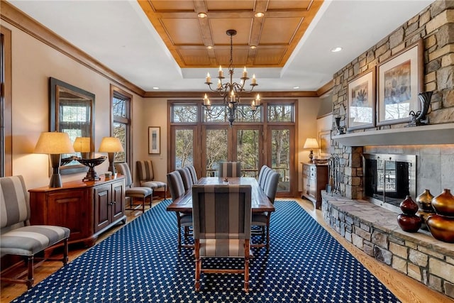 office area with hardwood / wood-style floors, a tray ceiling, a notable chandelier, a fireplace, and crown molding