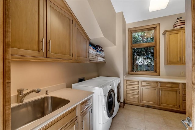 laundry area with light tile patterned flooring, sink, washing machine and clothes dryer, and cabinets