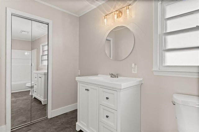 bathroom featuring vanity, toilet, crown molding, and plenty of natural light