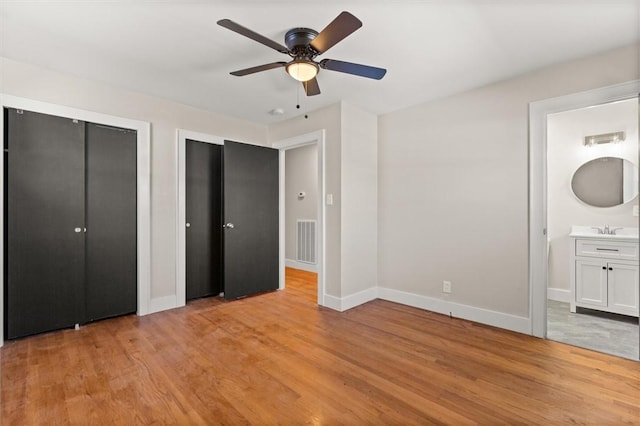 unfurnished bedroom with ceiling fan, light hardwood / wood-style floors, and ensuite bath