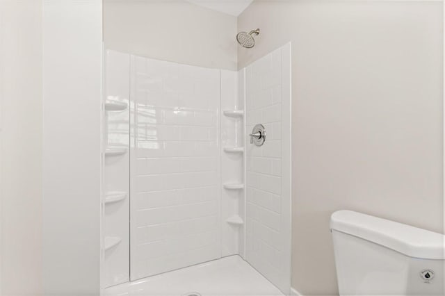 bathroom with toilet and tiled shower