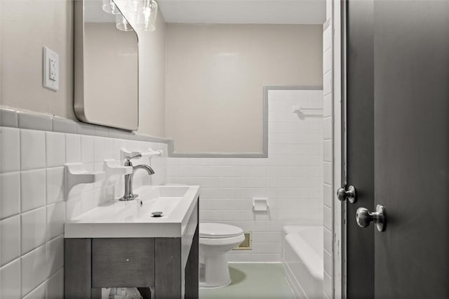 bathroom with tile walls, a tub to relax in, vanity, and toilet