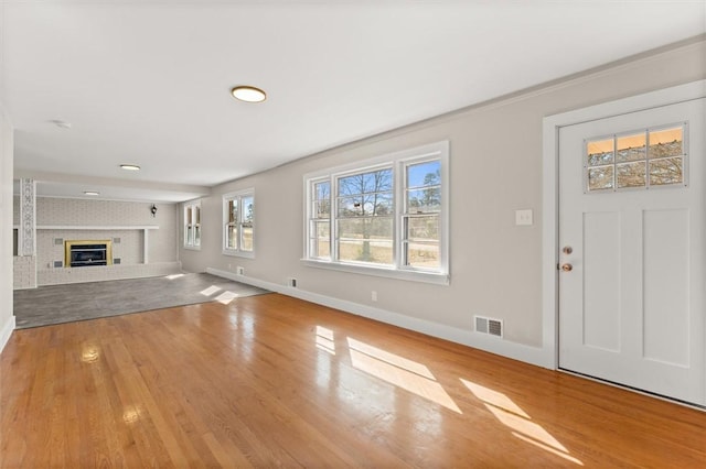 unfurnished living room featuring light wood-type flooring and a fireplace