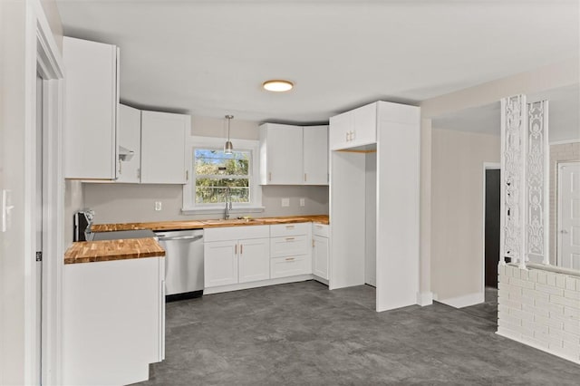 kitchen featuring appliances with stainless steel finishes, hanging light fixtures, wooden counters, white cabinets, and sink