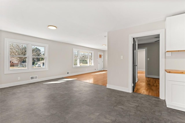 empty room featuring dark colored carpet and plenty of natural light