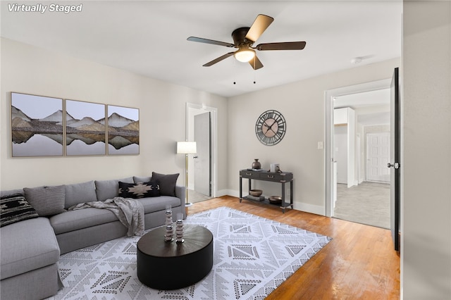 living room featuring hardwood / wood-style floors and ceiling fan