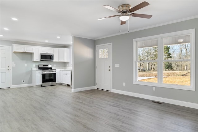 interior space featuring ceiling fan, light hardwood / wood-style floors, white cabinetry, and stainless steel appliances