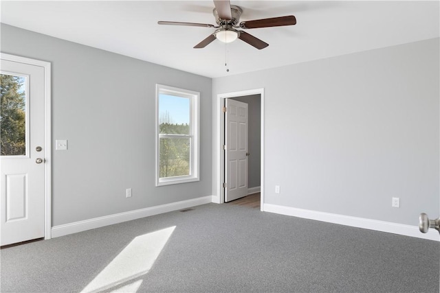 carpeted spare room featuring ceiling fan