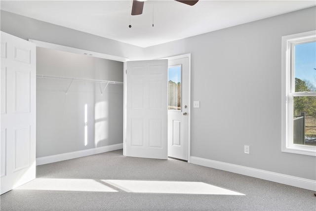 unfurnished bedroom with ceiling fan, multiple windows, a closet, and light carpet